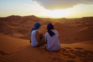Deux femmes assises dans le désert, Maroc